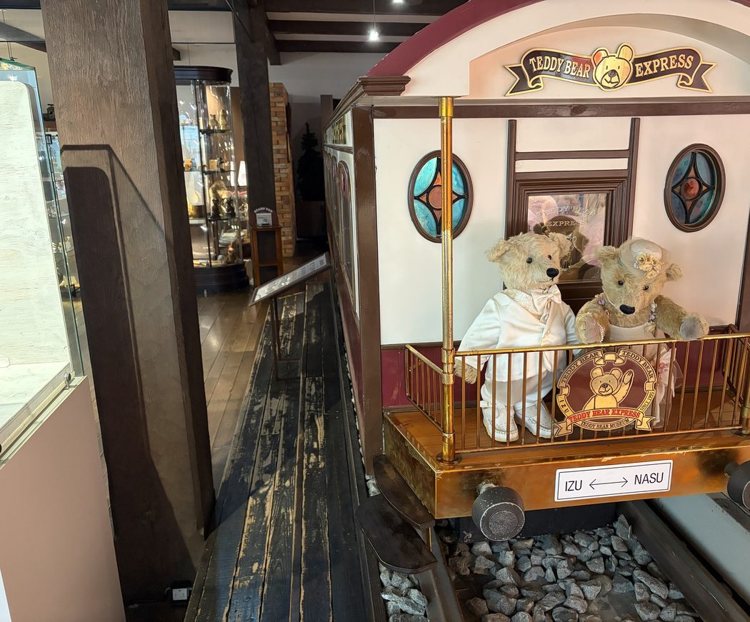 伊豆テディベア・ミュージアムの展示。列車の車両にテディベアが乗っていて、横に板張りの通路がある