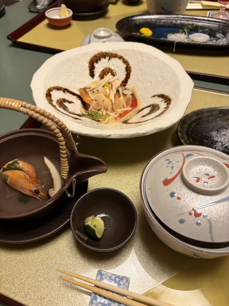 部屋で食べた夕食。土瓶に入った海老の汁物、焼いたサーモンにアーモンドをのせた皿、蓋付きの器